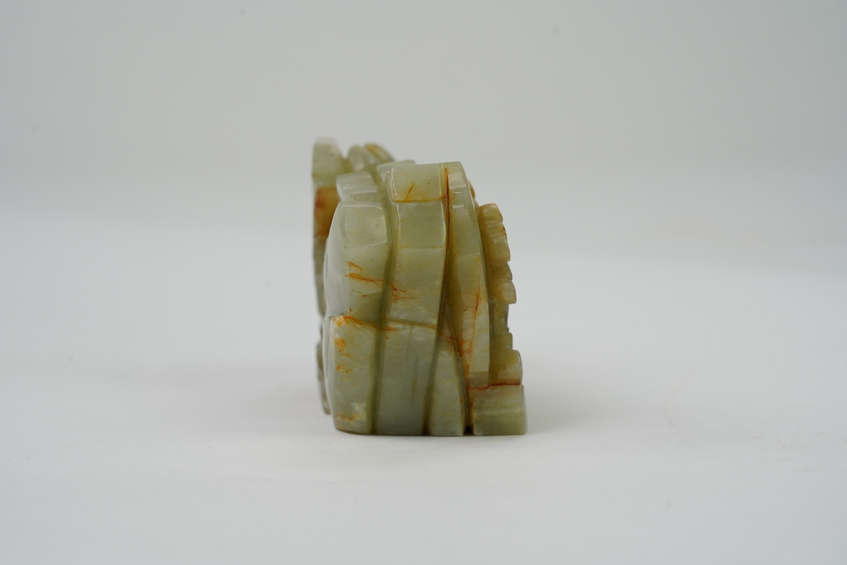 A Chinese celadon and russet jade boulder carving